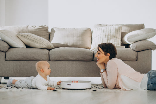 Jeune maman organisant les tâches ménagères avec un bébé, illustrant des astuces de rangement rapide et efficace.