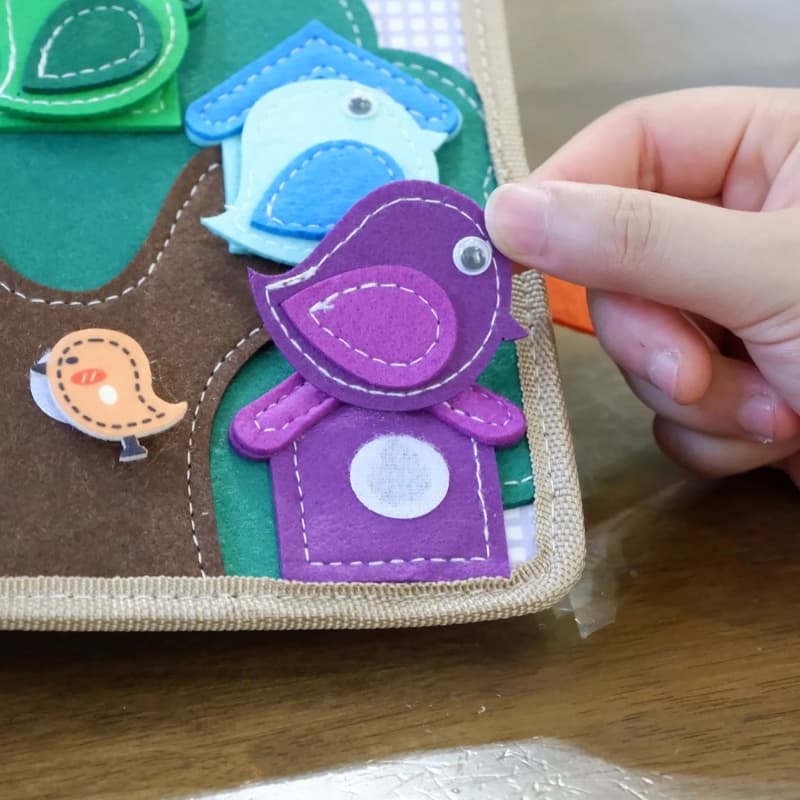 Livre en tissu pour bébé avec éléments interactifs pour stimuler la curiosité
